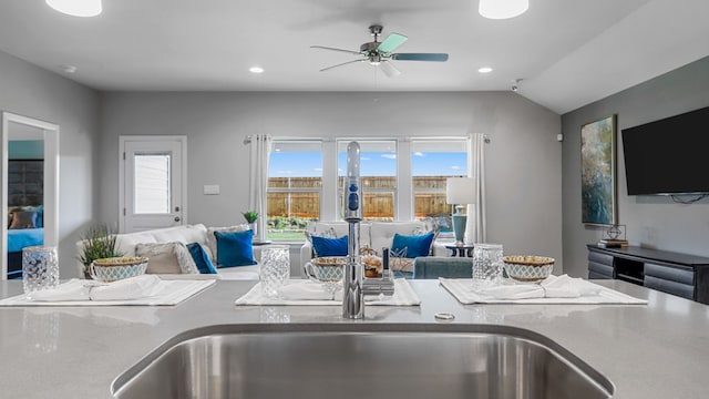 kitchen with ceiling fan, sink, and vaulted ceiling