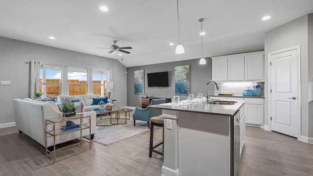 kitchen with a sink, open floor plan, ceiling fan, recessed lighting, and light wood-style flooring