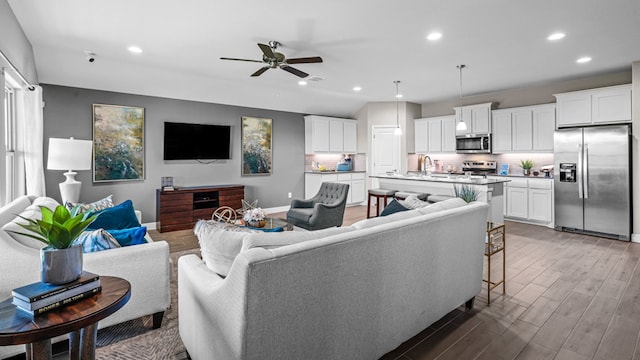 living room with ceiling fan, dark hardwood / wood-style flooring, and sink