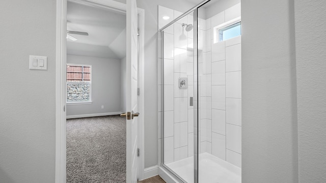 bathroom with lofted ceiling, ceiling fan, and walk in shower