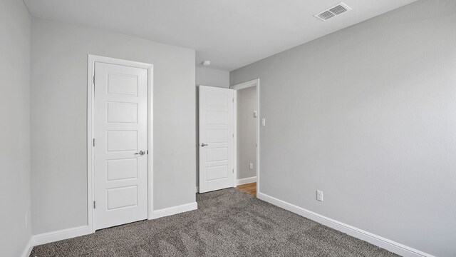 unfurnished bedroom featuring dark colored carpet