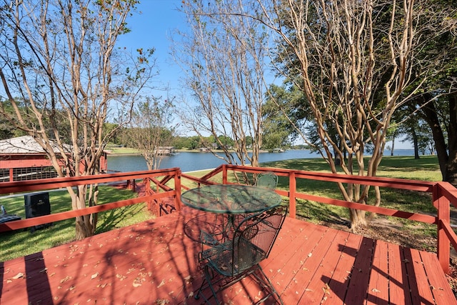 wooden terrace with a yard and a water view