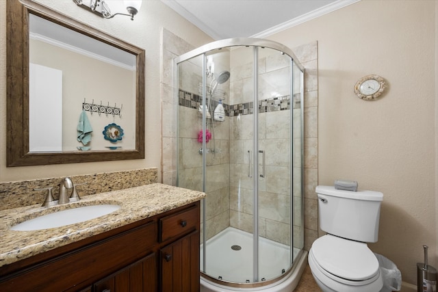 bathroom featuring toilet, crown molding, vanity, and a shower with door