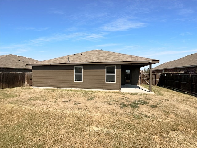 rear view of property with a yard and a patio