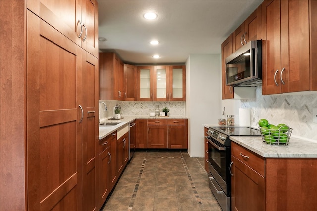 kitchen featuring tasteful backsplash, appliances with stainless steel finishes, sink, and light stone counters