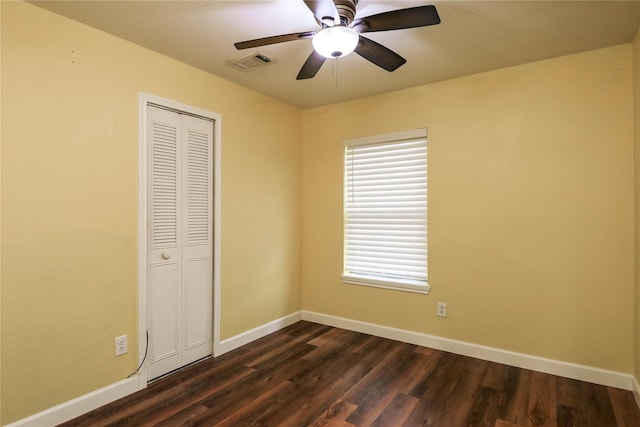 unfurnished bedroom with ceiling fan, a closet, and dark hardwood / wood-style floors