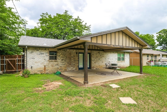 back of house featuring a lawn and a patio area