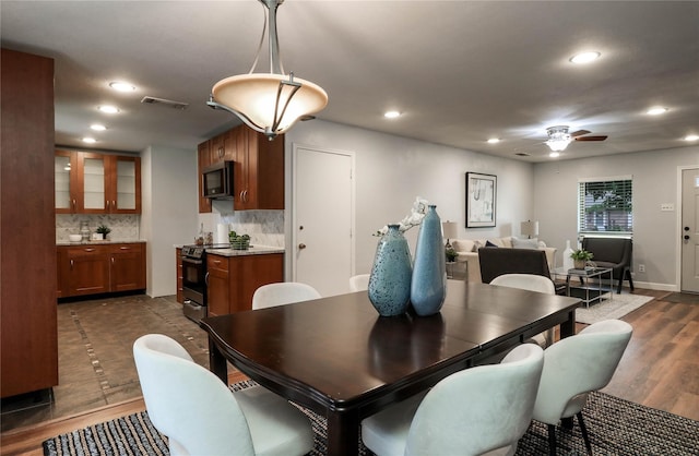 dining space with ceiling fan and dark hardwood / wood-style flooring