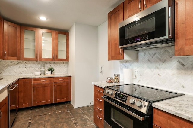 kitchen featuring appliances with stainless steel finishes, light stone counters, and backsplash