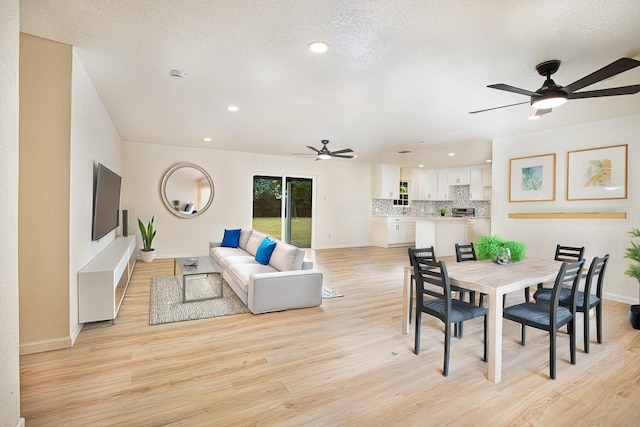 dining room with ceiling fan, light hardwood / wood-style floors, and a textured ceiling