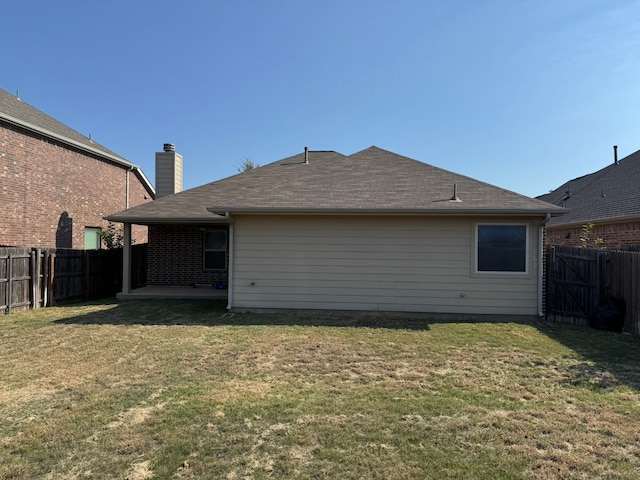 back of property featuring a lawn and a patio