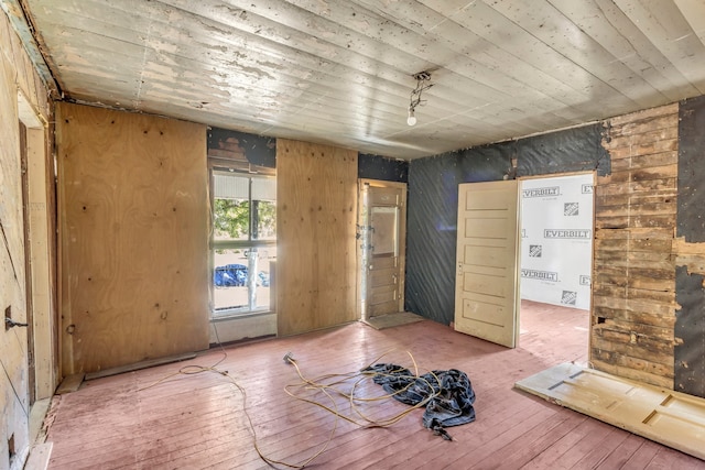 interior space with hardwood / wood-style flooring and wooden walls