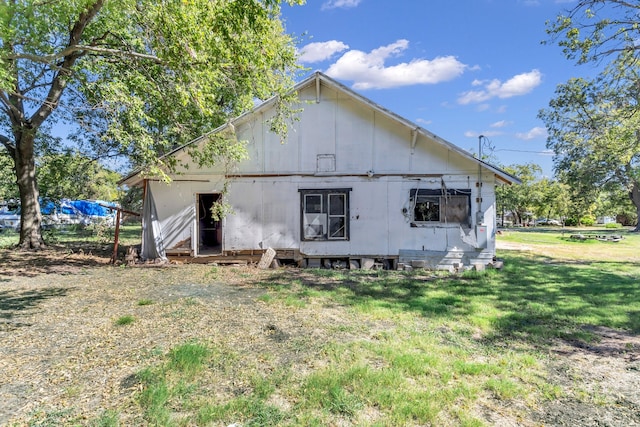 rear view of house featuring a yard