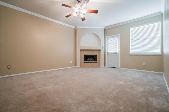 unfurnished living room featuring crown molding, light colored carpet, a tile fireplace, and ceiling fan