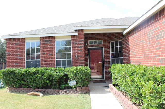 view of exterior entry with a yard