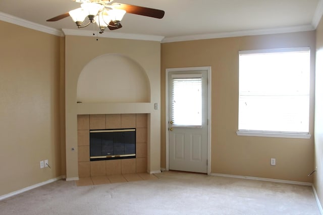 unfurnished living room with crown molding, light colored carpet, a tile fireplace, and ceiling fan