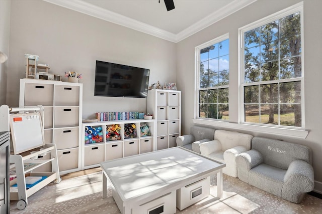 interior space with ornamental molding and a ceiling fan