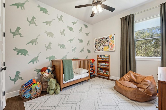 bedroom featuring wallpapered walls, a ceiling fan, light wood-style flooring, and baseboards