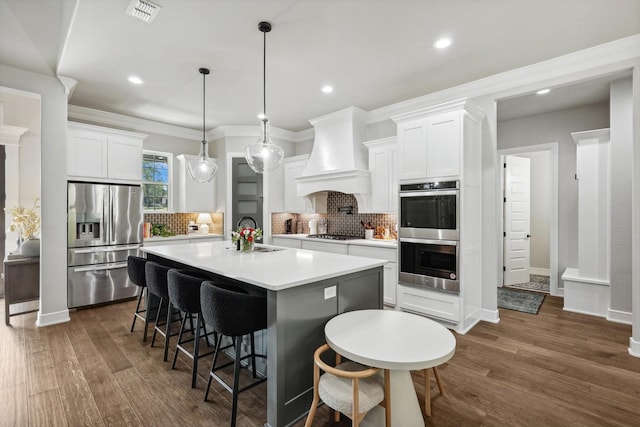 kitchen featuring stainless steel appliances, custom exhaust hood, light countertops, and white cabinets