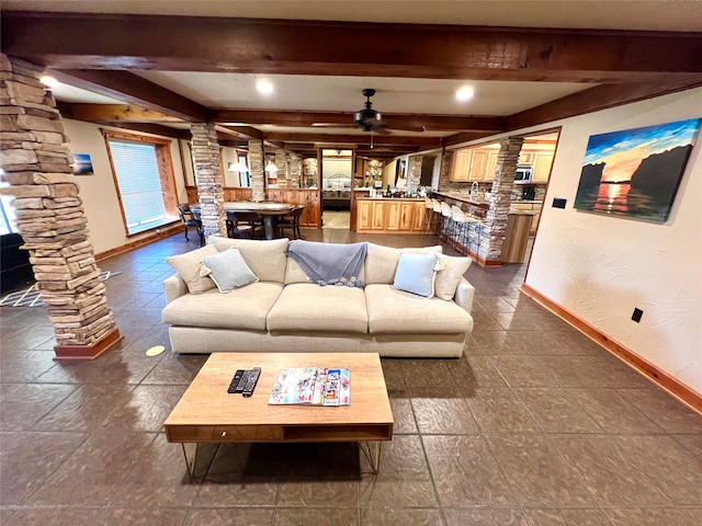 living room featuring ornate columns, beam ceiling, and ceiling fan