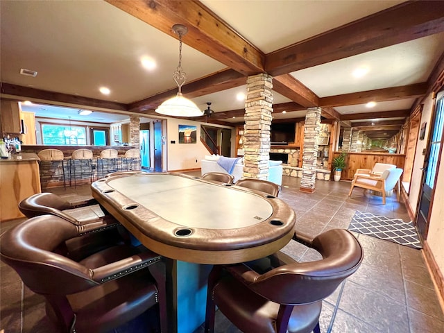 rec room featuring beamed ceiling, ornate columns, and indoor bar