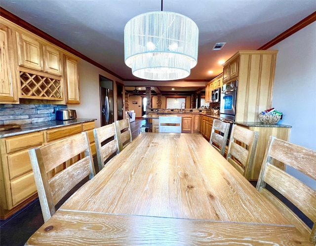 tiled dining area featuring crown molding and a chandelier