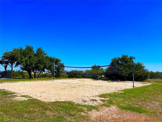 view of property's community with a yard and volleyball court