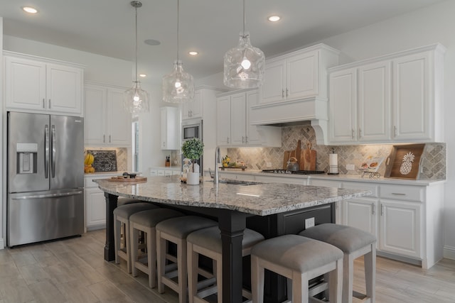 kitchen with appliances with stainless steel finishes, sink, and white cabinets