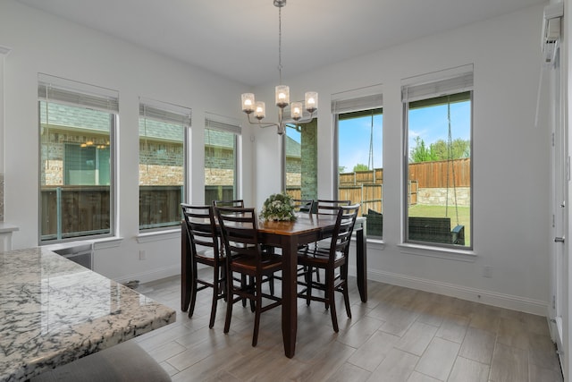 dining room with an inviting chandelier, light wood-type flooring, and plenty of natural light