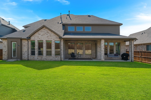 rear view of property with a yard and a patio area