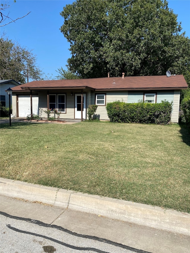 ranch-style house featuring a front yard and a garage