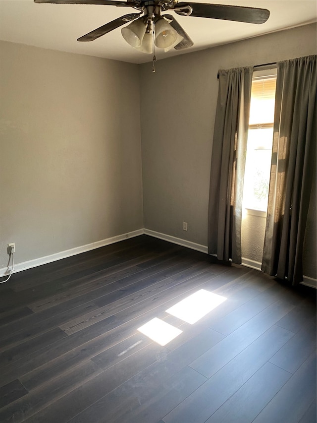 spare room with ceiling fan and dark wood-type flooring