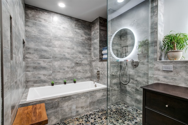 bathroom with vanity, tile walls, and independent shower and bath