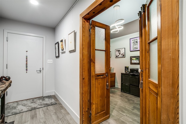 interior space featuring an inviting chandelier and light hardwood / wood-style floors