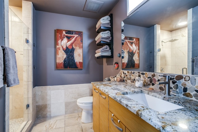 bathroom featuring vanity, tile walls, tile patterned floors, an enclosed shower, and toilet