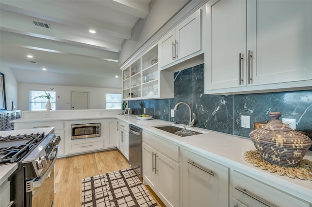 505 Sandra Dr, Irving, TX 75060 - kitchen featuring stainless steel appliances, backsplash, light countertops, a sink, and light wood-style flooring