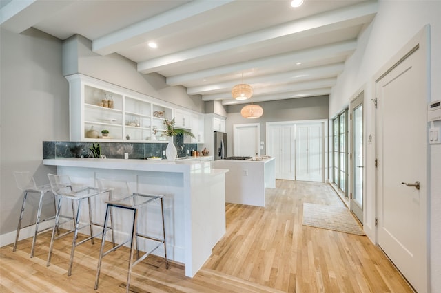 505 Sandra Dr, Irving, TX 75060 - kitchen featuring stainless steel refrigerator with ice dispenser, beam ceiling, white cabinetry, light wood-style floors, and open shelves