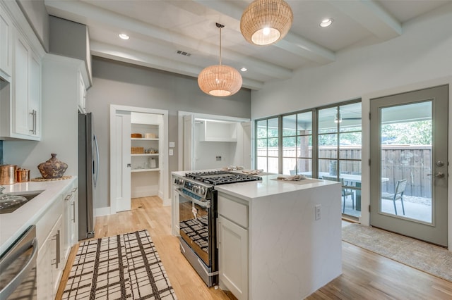 505 Sandra Dr, Irving, TX 75060 - kitchen with stainless steel appliances, healthy amount of natural light, beamed ceiling, white cabinets, and light wood-style flooring