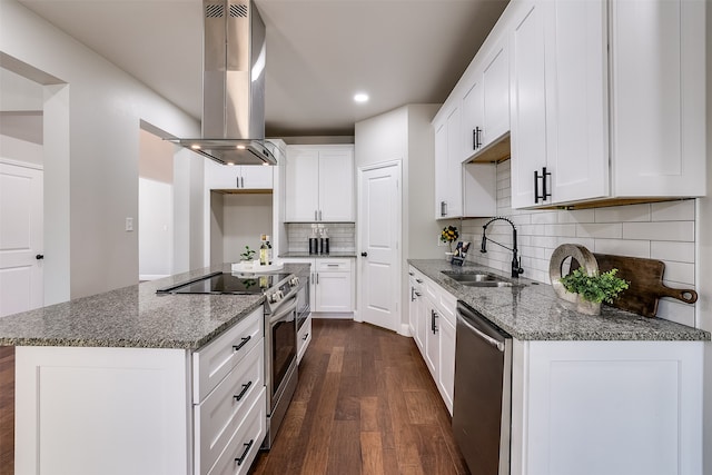 kitchen with extractor fan, dark wood-type flooring, decorative backsplash, appliances with stainless steel finishes, and white cabinetry