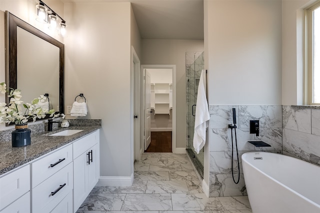 bathroom with separate shower and tub, vanity, and tile walls