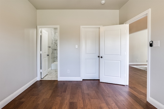 unfurnished bedroom with connected bathroom and dark hardwood / wood-style flooring