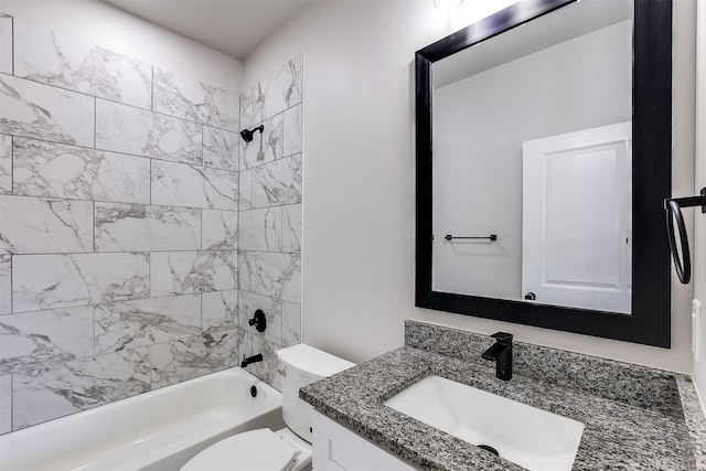 full bathroom featuring tiled shower / bath, vanity, and toilet