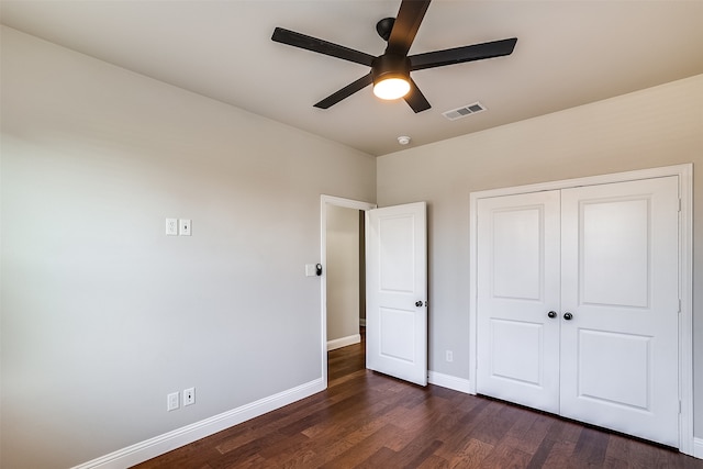 unfurnished bedroom featuring a closet, dark hardwood / wood-style flooring, and ceiling fan