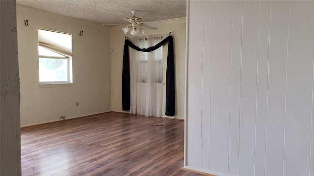 spare room featuring a textured ceiling, a ceiling fan, and wood finished floors