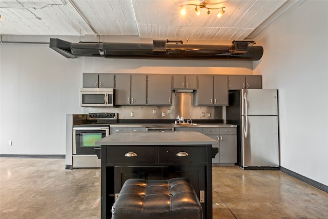 kitchen featuring gray cabinetry, stainless steel appliances, sink, and a kitchen island