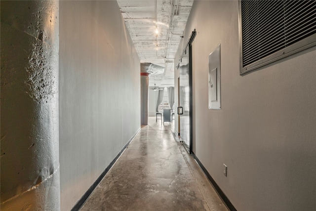 hall featuring concrete flooring and electric panel