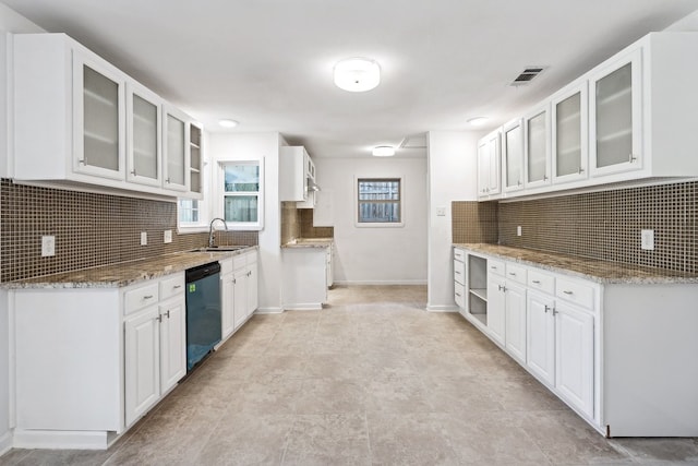 kitchen featuring light stone counters, decorative backsplash, white cabinetry, and dishwasher