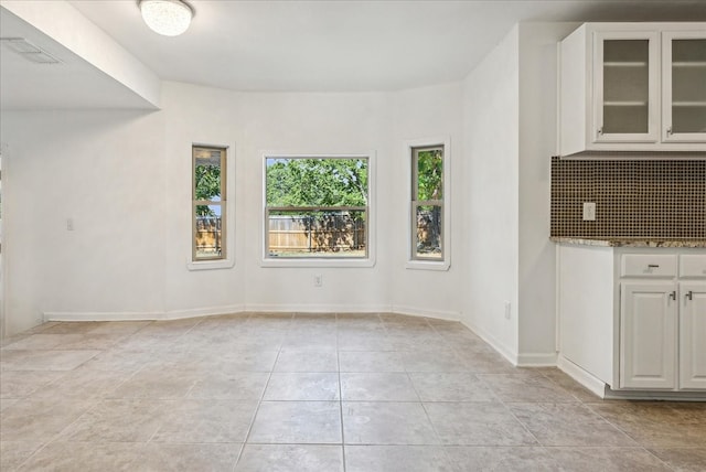 unfurnished dining area featuring light tile patterned flooring