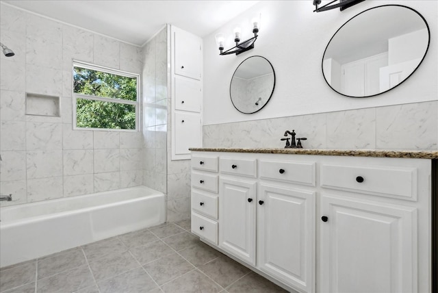 bathroom with tiled shower / bath, vanity, and tile patterned flooring