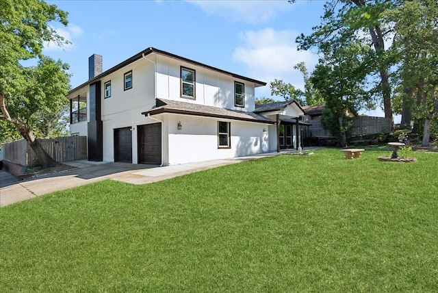 back of property featuring a lawn and a garage